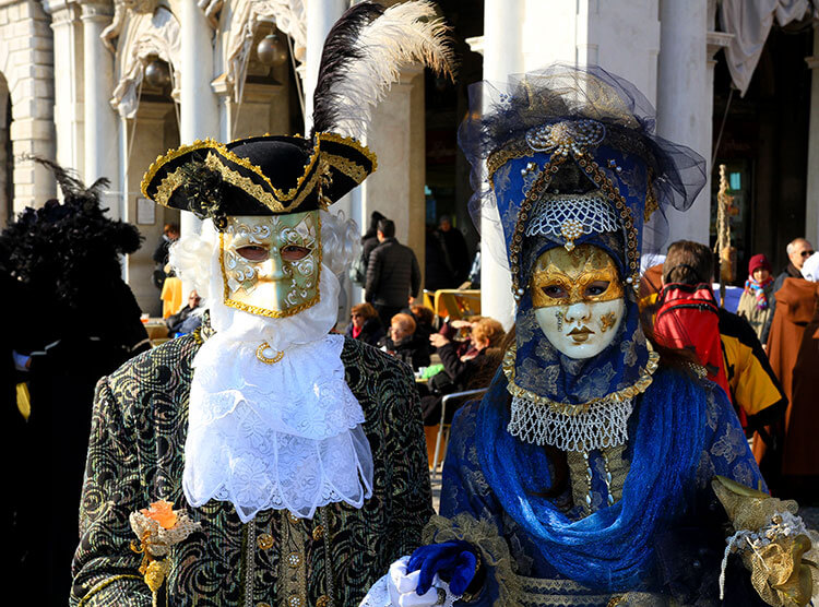 A man wears a decorated Batua Venice Carnival mask with the 3 tip hat