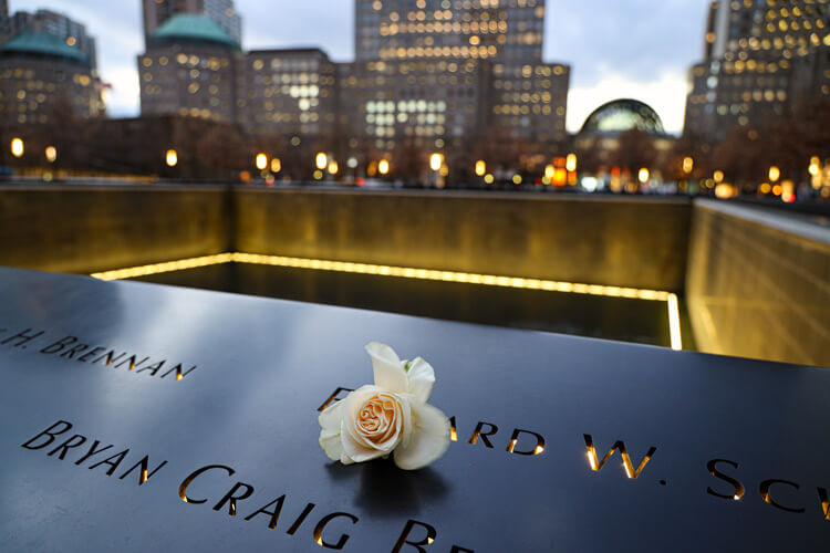 A white roses sits atop some names at the 9/11 Memorial in NYC