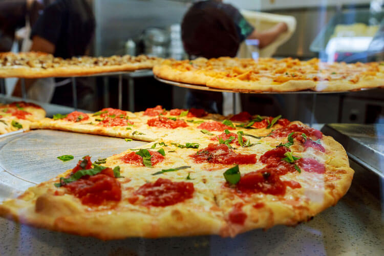 New York-style pizzas on display at Joe's Pizza in NYC