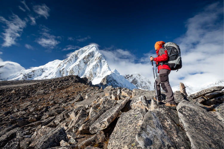 A woman stops to admire a snowy Nepal peak on a climbing expedition