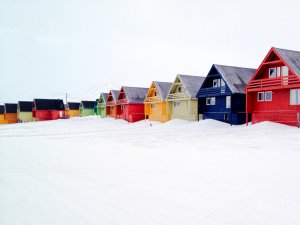 A row of houses painted in various colors and built on stilts in Longyearbyen, Svalbard