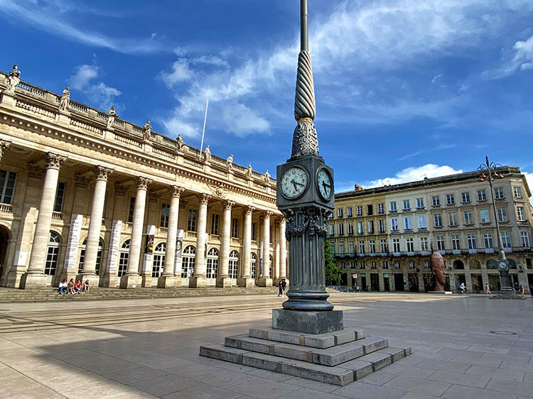 The famous clocks of Place de la Comedia pictured at 5:20pm on a sunny afternoon when the square is nearly empty during the COVID-19 crisis