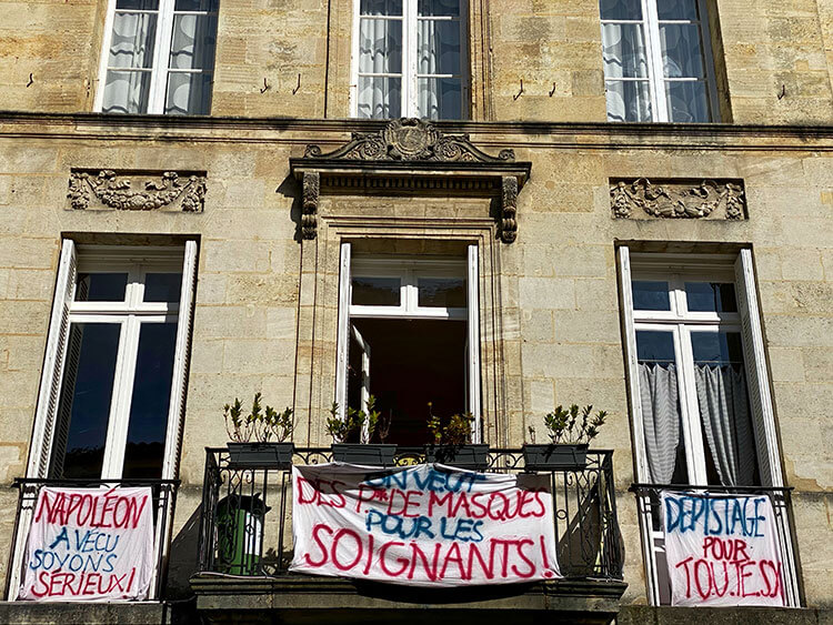 Protest banners hang from balconies in Bordeaux, France during the COVID-19 lockdown