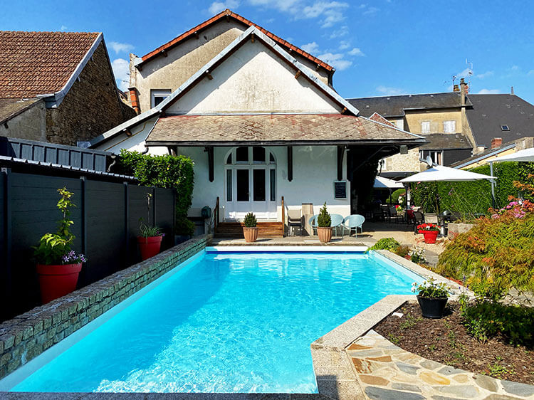 The pool and historic buildings that house the hotel at Hotel Nougier in Creuse