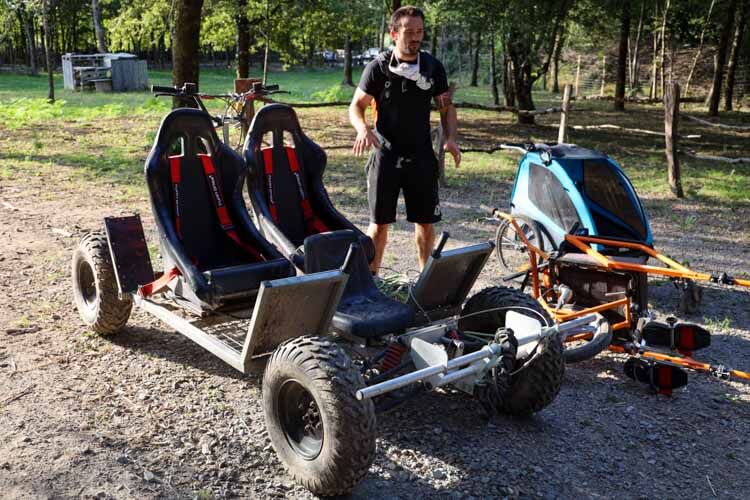 Owner Julien stands next to the 4-wheel cart that the huskies can pull in cooler temperatues at Husk'in Creuse