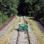Jennifer and Tim pedal across a bridge on the rail bike at the Velo Rail de la Mine