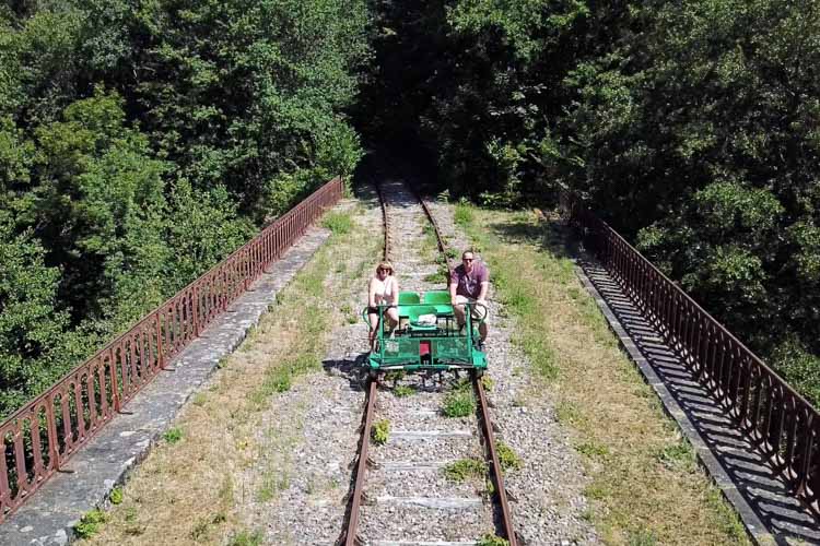 Jennifer and Tim pedal across a bridge on the rail bike at the Velo Rail de la Mine 