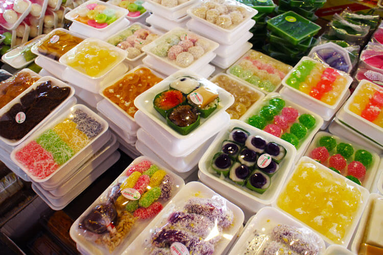 A cart is covered with multicolored desserts packaged for purchase in Bangkok's Chinatown