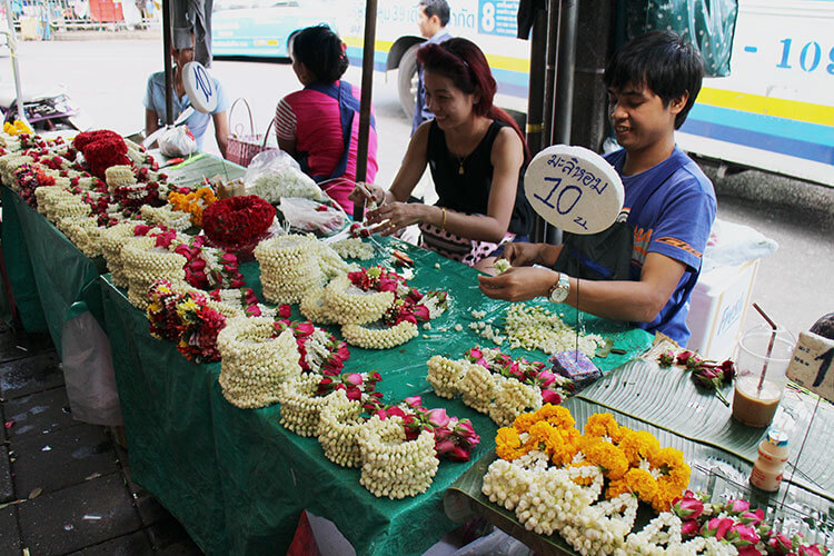 Thais string flower garlands and sell them at the Pak Khlong Talat flower market in Bangkok