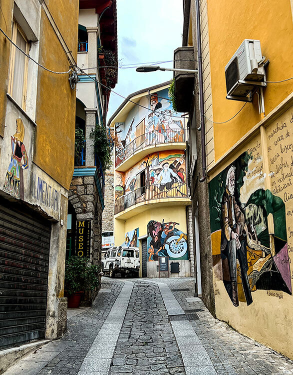 A street in Orgosolo with every building covered in a mural