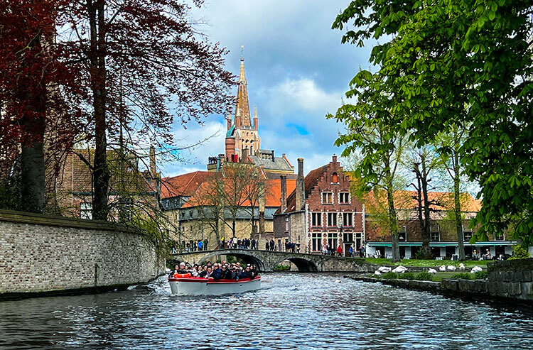 A canal boat tours Minnewater Lake and the canals of Bruges, Belgium