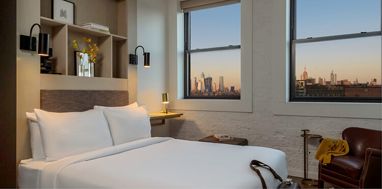 A hotel room with queen bed and New York City skyline view at Hotel Walker Tribeca in New York City