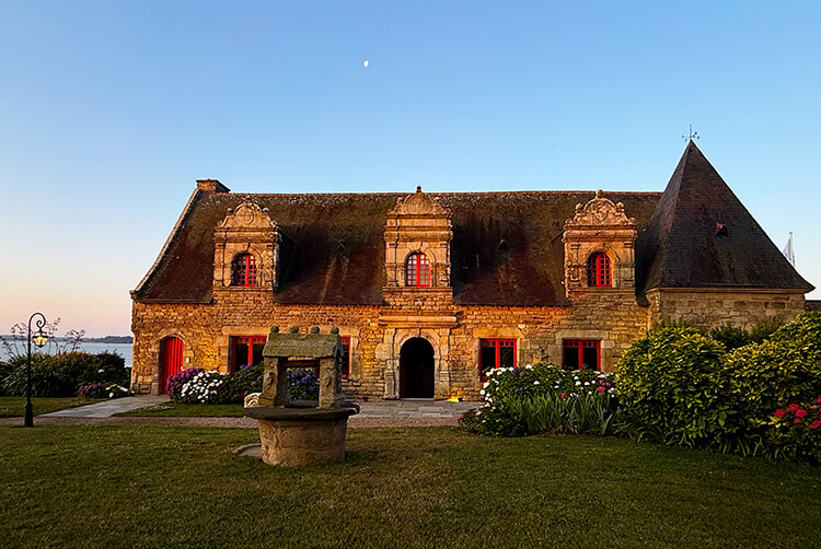 The 16th century stone Le Manoir Renaissance in the golden light of sunset at Domaine de Rochevilaine