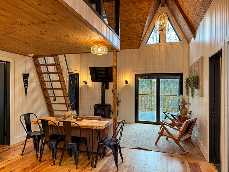 The central living room in Jubliee with a fireplace, flatscreen tv and handcrafted furniture