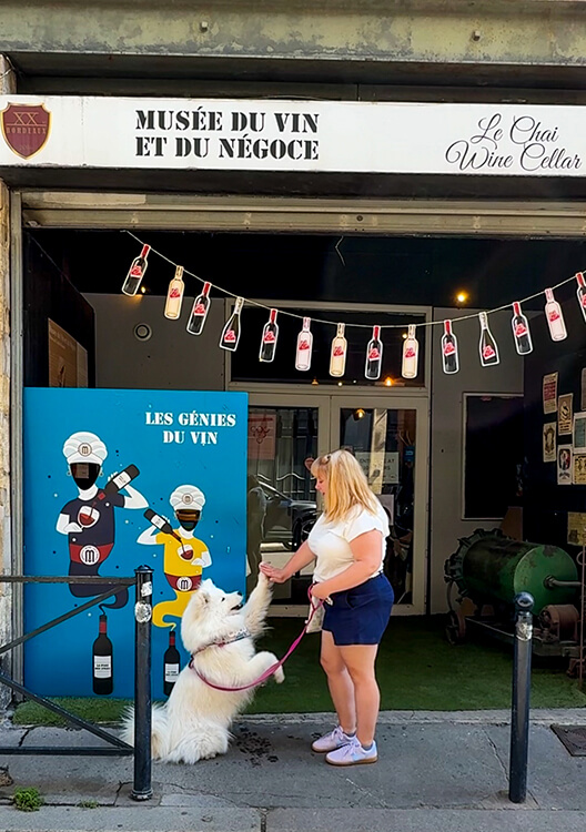Coco and Jennifer high five outside the entrance of the Musée du Vin et du Négoce