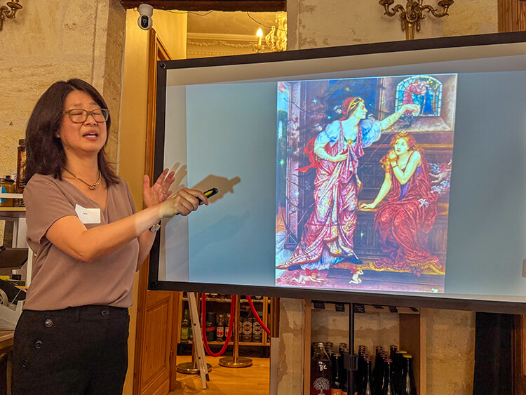 Jane explains the painting in the Revealing Queen Eleanor and Her Wines experience at a wine shop in Bordeaux, France