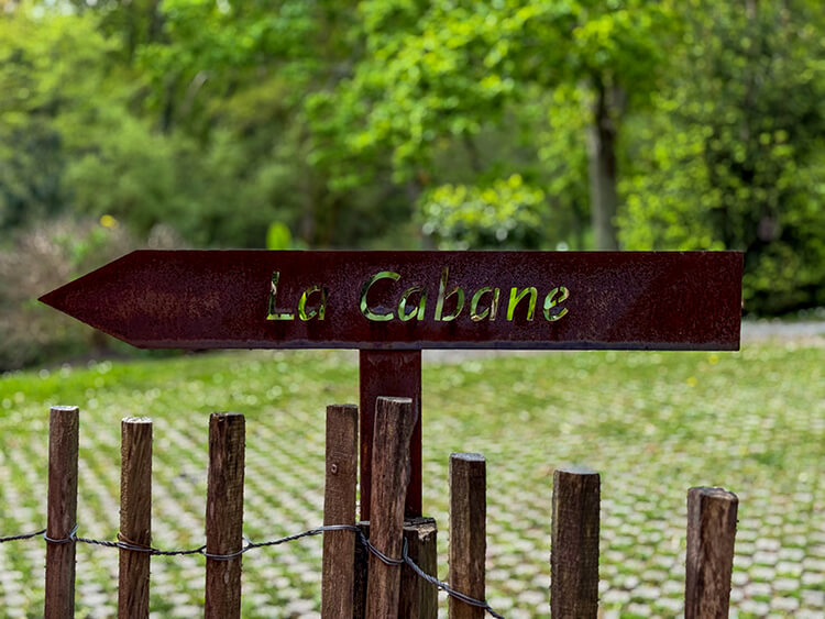 A sign in the garden points the way to the Nordic Spa at Les Frères Ibarboure