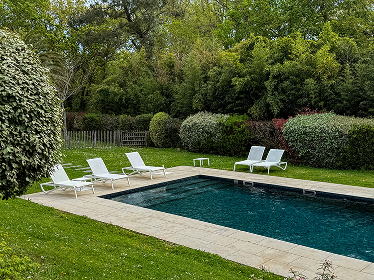 The pool with loungers and umbrellas at Les Frères Ibarboure