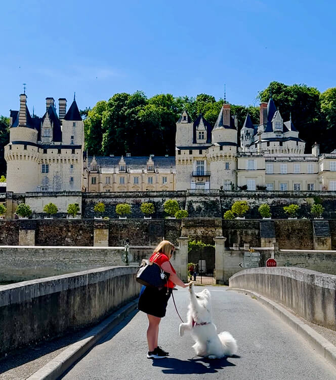 Coco and Jennifer high five on the stone bridge with Château d'Ussé rising up behind them in the Loire Valley