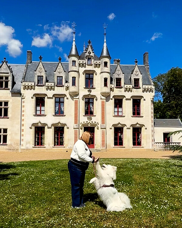 Jennifer and Coco high five in front of the castle of Château de la Grille in the Loire Valley