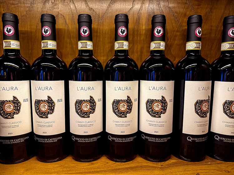 A shelf of bottles of L'aura Chianti Classico in the boutique at Querceto di Castellina